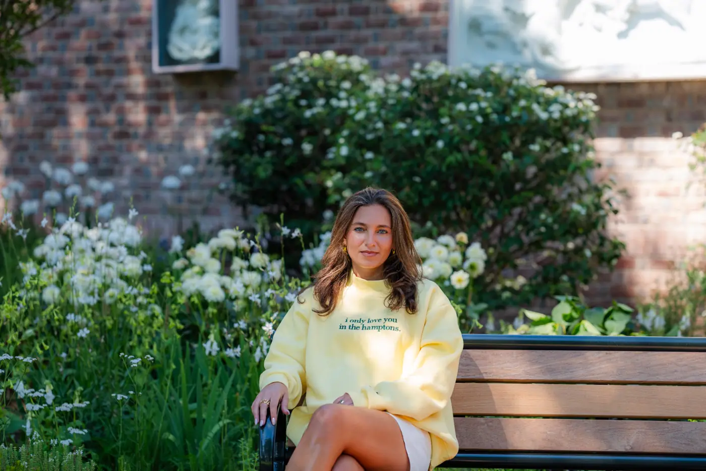Yellow crewneck, hand in hair on the bench