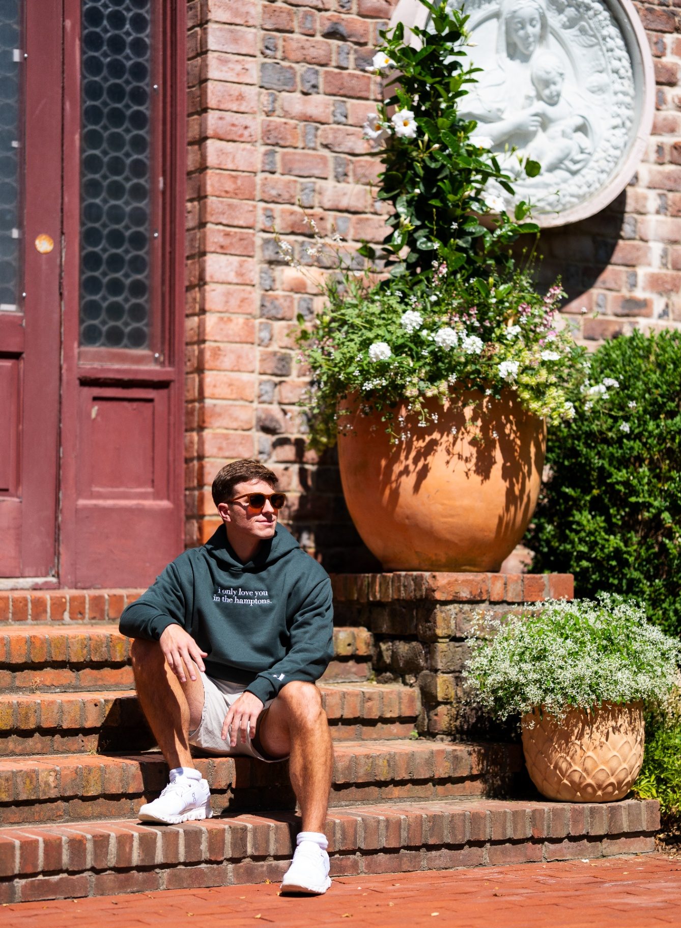 Green hoodie in the brick-walled side yard